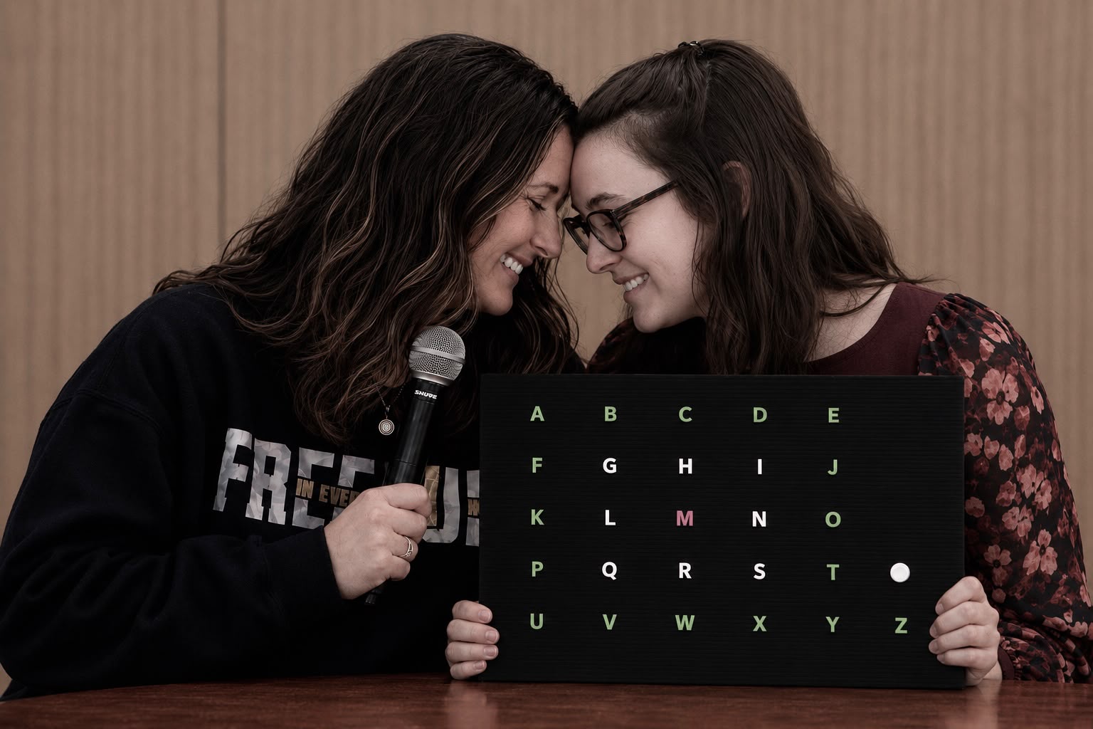 Heather Burroughs and Devyn Pereira holding a letterboard together.